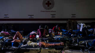 Des migrants sur des lits de camp attendent sur l’île italienne de Lampedusa, le 14 septembre, avant leur transfert en Sicile.