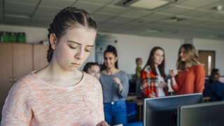 A teenage student is the victim of cyber bullying, looking sad