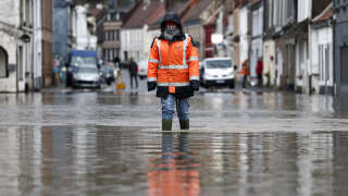 Un habitant marche dans une rue inondée à Neuville-sous-Montreuil, dans le nord de la France, le 9 novembre 2023.