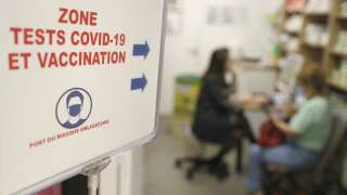 A woman speaks to a pharmacy employee before receiving a dose of Comirnaty Omicron XBB 1.5 Pfizer vaccine for COVID-19 at a pharmacy in Ajaccio, on October 5, 2023, during a new COVID-19 vaccination campagin on the French Mediterranean island of Corsica. (Photo by Pascal POCHARD-CASABIANCA / AFP)