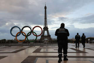Security guards patrol at sunrise by the Olympic rings installed on the Esplanade du Trocadero near the Eiffel tower following the Paris' nomination as host for the 2024 Olympics, on September 14, 2017 in Paris. (Photo by LUDOVIC MARIN / AFP)