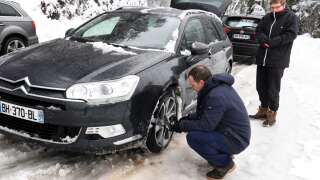 Photo d’illustation d’automobilistes qui installent des chaînes à neige sur les pneus de leur voiture à Beaufort, dans le centre-est de la France, alors qu’ils se rendent dans les stations de ski des Alpes françaises. 