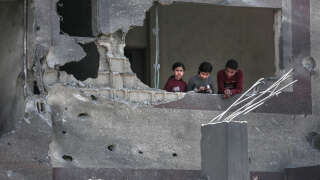 Des Palestiniens à la fenêtre d’un bâtiment endommagé à la suite d’un bombardement israélien, à Gaza, le 20 mars 2024.