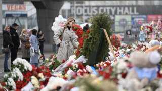 People visit a makeshift memorial in front of the Crocus City Hall in Moscow's northern suburb of Krasnogorsk on March 29, 2024, a week after a deadly attack by gunmen on the Moscow concert hall, setting the building alight and killing at least 143 people. Four gunmen stormed the Crocus City venue before the start of a rock concert on March 22, opened fire on the audience and set fire to the building, in an assault claimed by the Islamic State group. (Photo by NATALIA KOLESNIKOVA / AFP)