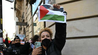 A protester, who hold a poster depicting a Palestinian flag, is escorted away by French gendarmes during the evacuation of a pro-Gaza sit-in in the entrance hall of the Institute of Political Studies (Sciences Po Paris) in Paris on May 3, 2024. One student told reporters that around 50 students were still inside the rue Saint-Guillaume site when police entered. Students at Sciences Po have staged a number of protests, with some students furious over the Israel-Hamas war and ensuing humanitarian crisis in the besieged Palestinian territory of Gaza. (Photo by Miguel MEDINA / AFP)