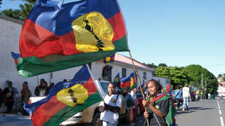 Protesters wave flags of the Socialist Kanak National Liberation Front (FLNKS) as they take part in a gathering organised by the pro-independence coalition of the Cellule de Coordination de Terrain (CCAT) outside the Noumea courthouse in support of 14 activists on trial for obstructing traffic and damaging property, on May 13, 2024. Several actions have been carried out by pro-independence activists over the last ten days, as the National Assembly examines the constitutional bill aimed at enlarging the electorate of New Caledonia. (Photo by Theo Rouby / AFP)