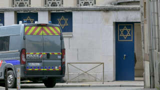A police vehicle is parked by an entrance of a synagogue in the Normandy city of Rouen where French police have killed earlier an armed man who was trying to set fire to the building on May 17, 2024. Two separate investigations have been opened, one into the fire at the synagogue and another into the circumstances of the death of the individual killed by the police, Rouen prosecutors said. The man threatened a police officer with a knife and the latter used his service weapon, he added. (Photo by LOU BENOIST / AFP)
