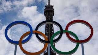 This photograph shows the Olympic Rings displayed at the construction site of the Eiffel Tower Stadium for the upcoming Paris 2024 Olympics and Paralympic Games which will host the Beach Volleyball and men's Blind Football competitions, at the Champ-De-Mars in Paris on July 10, 2024. The Champ de Mars and the Trocadero, located on either side of the Eiffel Tower, will host several events of the Paris Olympic and Paralympic Games, on July 10, 2024. (Photo by Dimitar DILKOFF / AFP)