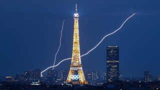 A lightning strike is seen close to the Eiffel Tower during the Paris 2024 Olympic Games in Paris on August 1, 2024. (Photo by Luis ROBAYO / AFP)