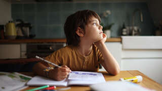 A little boy daydreaming at homework time